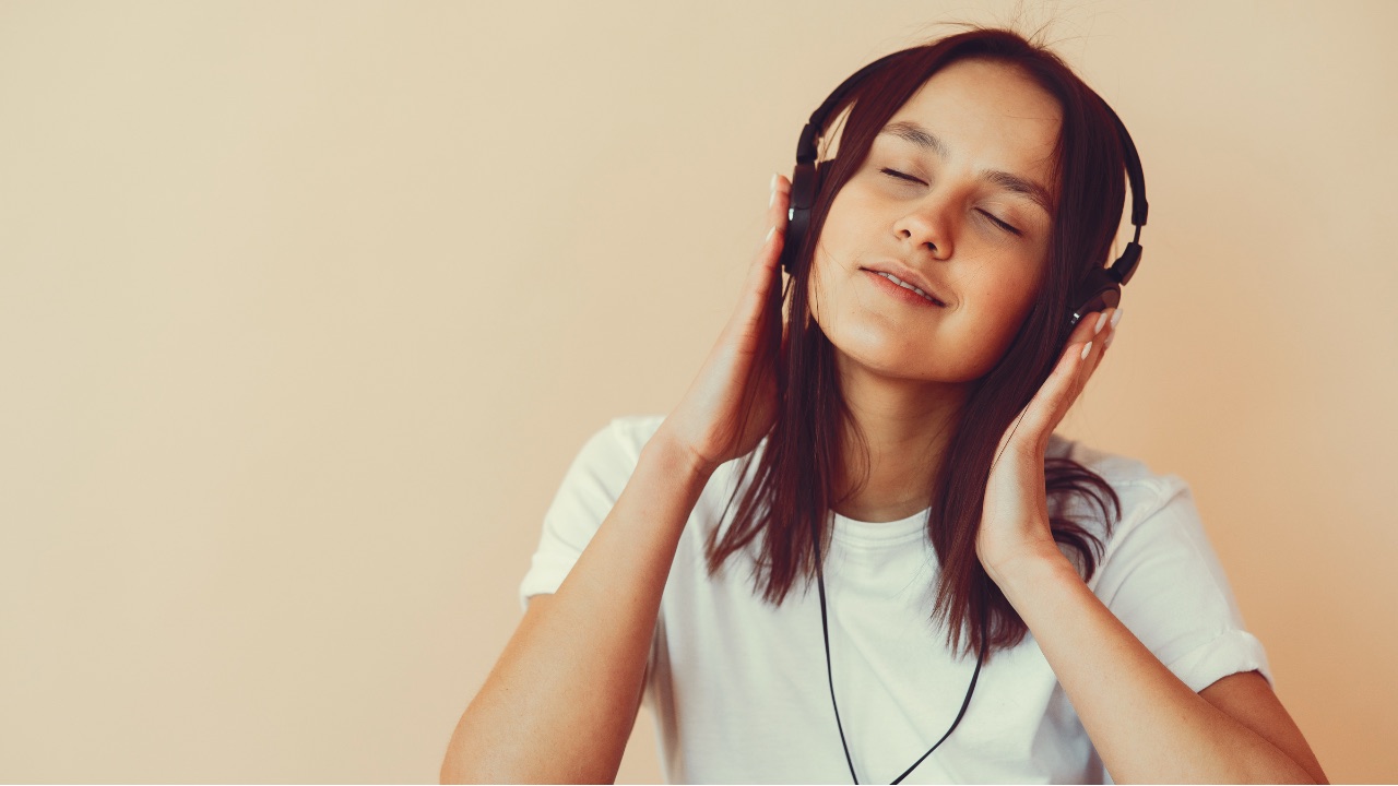 ヘッドホンで音楽を聴きながら目を閉じる女性